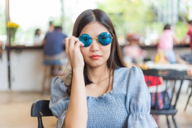 Gülümseyen girişimci kadınlar kahve dükkanında oturup iş hakkında düşünürler.