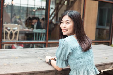 Gülümseyen girişimci kadınlar kahve dükkanında oturup iş hakkında düşünürler.