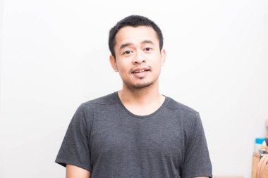 Çekici, gülümseyen Asyalı yakışıklı erkekler beyaz arka planda günlük gömlekler giyerler.