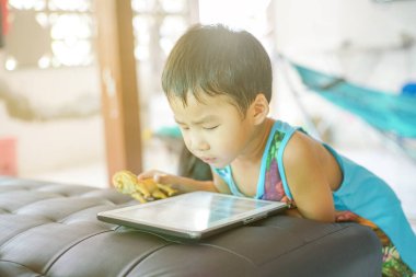 Tablet bilgisayar oynayan Asyalı çocuk İnternet tarayıcısı ve eğitim kavramına bağlandı