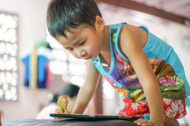 Tablet bilgisayar oynayan Asyalı çocuk İnternet tarayıcısı ve eğitim kavramına bağlandı