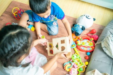 Oda eğitimi konseptinde tahta oyuncakla eğlenen komik çocuklar grubu.