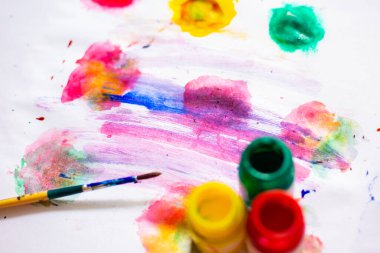 Beyaz sanat kağıdının üzerine çeşitli renklerde suluboya boya boya.