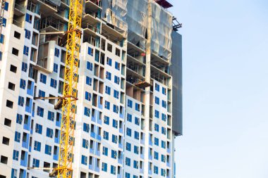 Mavi gökyüzü inşaat endüstrisine karşı vinçli modern yüksek binalar inşa ediyoruz.