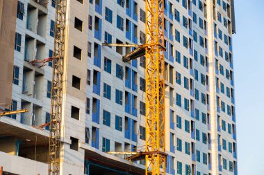 Mavi gökyüzü inşaat endüstrisine karşı vinçli modern yüksek binalar inşa ediyoruz.