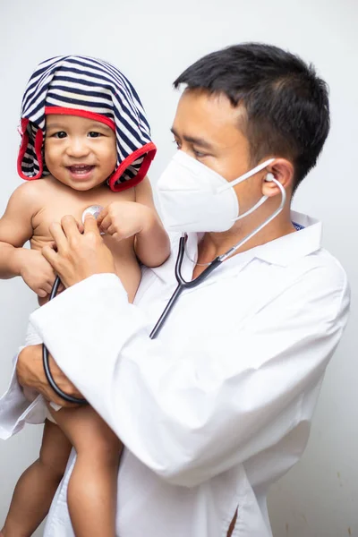 Doctor in lab cover suit mask holding baby boy Corona virus test blood in tube on white background