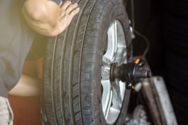 Mekanik araba garajı değişiyor ve arabanın lastiğini mekanik stabil motorla değiştiriyor.