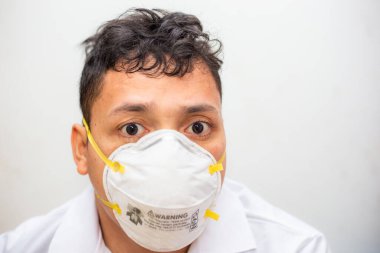 N95 mank giyen Asyalı adam beyaz arka planda Covid19 ve Pm2.5 'tan korunuyor.