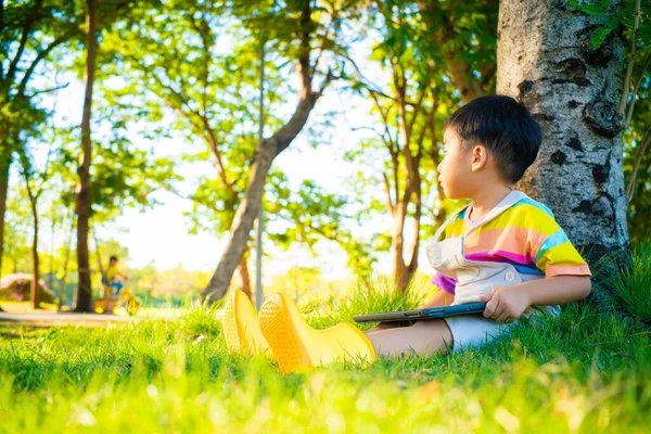 Adorable Niño Sentado Bajo Árbol Parque Ciudad Utilizar Tableta Ordenador — Foto de Stock