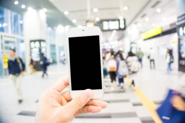 Bulanık insanlar tren istasyonunda yoğun saatlerde ellerinde boş ekranla