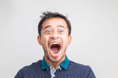 Genç Asyalı adamın portresi beyaz arka planda şok edici yüz ifadesi