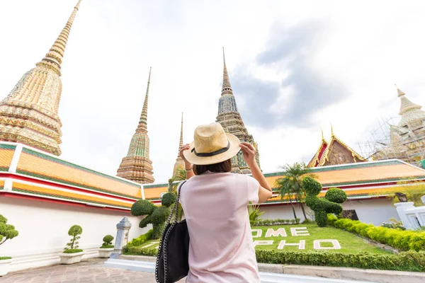 Asian tourist women with sun protect hat travel in Wat Pho Temple, Bangkok Thailand