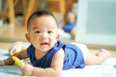Bebek çocuk battaniyenin üzerinde emekliyor lastik dişli oyuncak, sağlıklı çocuk