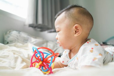 Bebek çocuk battaniyenin üzerinde emekliyor lastik dişli oyuncak, sağlıklı çocuk