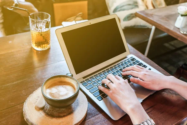 Kvinder Hånd Tæt Skrive Bærbar Computer Med Kop Latte Kunst - Stock-foto