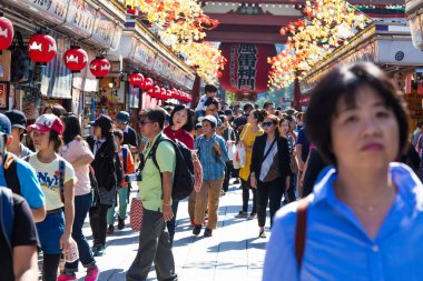 ASAKUSA, TOKYO, JAPAN - 20 Ekim 2016: Asakusa 'daki Nakamise alışveriş caddesinde güneşli bir günde eğlenen turistler Tokyo' nun en popüler yerlerinden Asakusa 'daki Sensoji Tapınağı' na bağlanıyorlar.