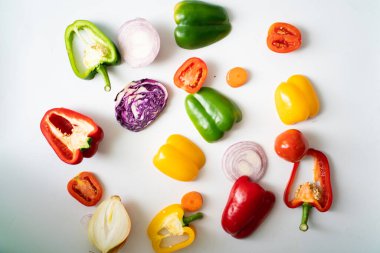 Beyaz arka planda acı biber dilimleri, renkli sebzeler.