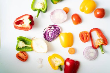 Beyaz arka planda acı biber dilimleri, renkli sebzeler.