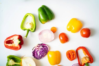 Beyaz arka planda acı biber dilimleri, renkli sebzeler.