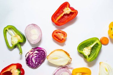 Beyaz arka planda dilimlenmiş renkli sebze seti, sağlıklı besin düzlüğü