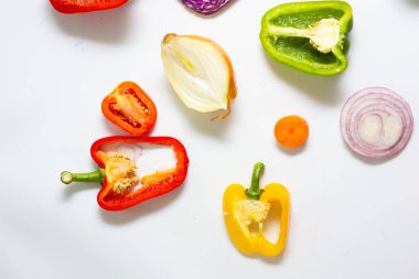 Beyaz arka planda dilimlenmiş renkli sebze seti, sağlıklı besin düzlüğü