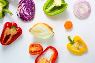 Beyaz arka planda dilimlenmiş renkli sebze seti, sağlıklı besin düzlüğü