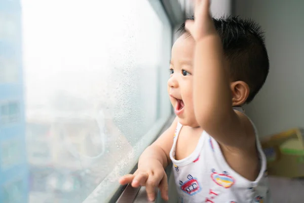 Mutlu Erkek Bebek Pencerenin Yanında Durur Dışarıdan Yağmur Yağmasını Bekler — Stok fotoğraf
