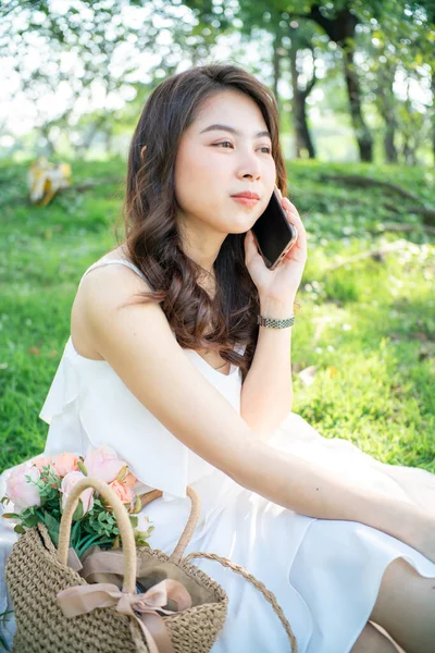 Attractive Asian Beautiful Women Sitting Green Grass Talking Smartphone City —  Fotos de Stock