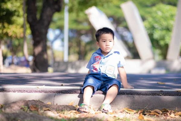 Щасливий Азіатський Хлопчик Відпочинок Сонячному Парку Розмитий Зелене Дерево Листя — стокове фото