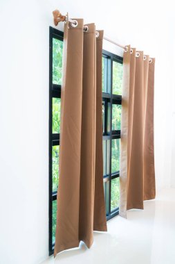 Beyaz yatak odasının iç dekorasyonunda bej bir perde.