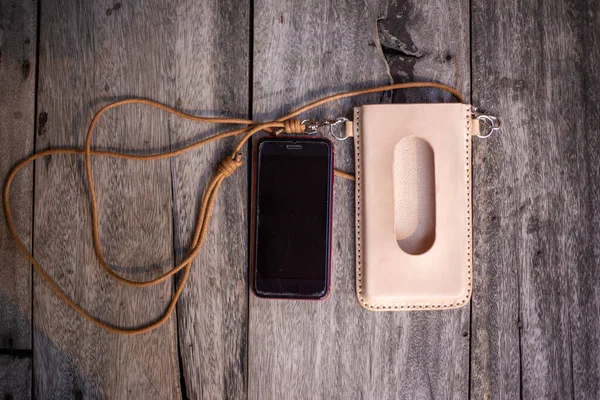 本革携帯電話カバーケース首上の木の背景 — ストック写真