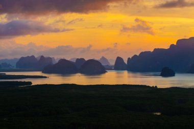 Mangrove ormanı körfezi silueti dağ manzarası renkli gökyüzü bulutu