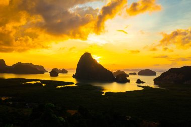 Mangrove ormanı körfezi silueti dağ manzarası renkli gökyüzü bulutu