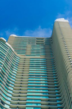 Yüksek gökdelen modern bina mavi gökyüzü arkaplanına karşı aşağıdan bakıyor