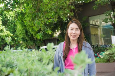 İş dünyasından Asyalı güzel kadınlar yeşil parkta durup gülümsüyor.