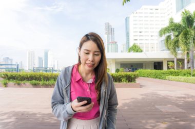 Şehir binasında akıllı telefon kullanan iş kadınları, güzel kadınlar.