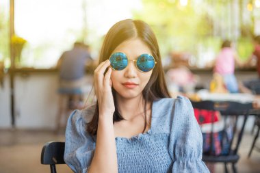 Yuvarlak güneş gözlüklü genç ve güzel kadınlar klasik kafede rahatlar, moda kadınları.