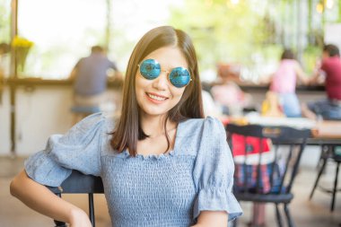 Yuvarlak güneş gözlüklü genç ve güzel kadınlar klasik kafede rahatlar, moda kadınları.