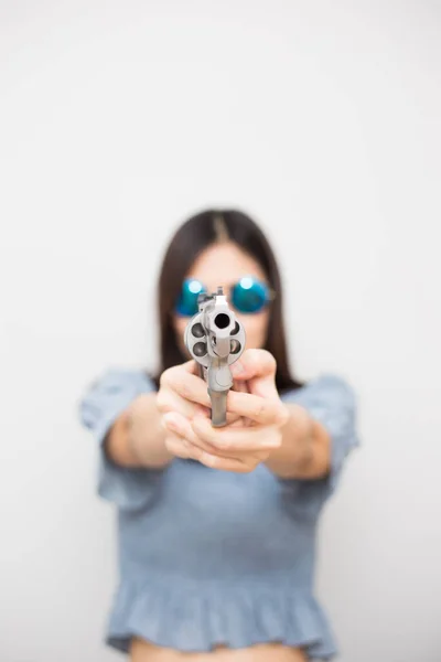 白い背景にカメラに回転銃を指すスマート美しい女性 — ストック写真