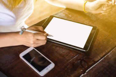 Yerel kahve dükkanında oturan Asyalı iş kadınları tablet bilgisayarda çalışıyorlar.