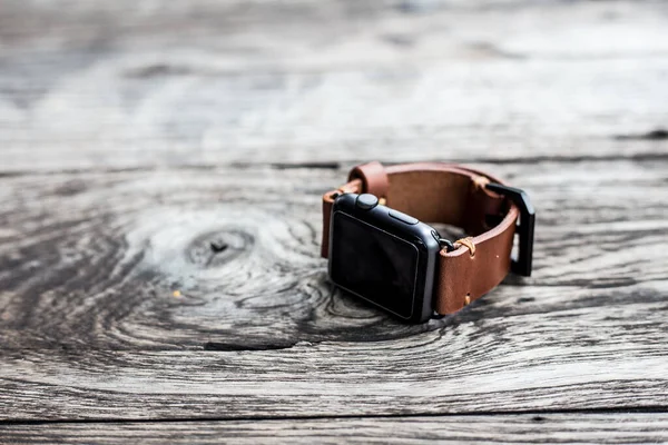 Genuine brown leather watch strap on wood background, Craftsmanship working object