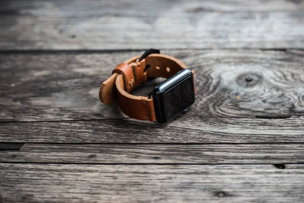 Genuine brown leather watch strap on wood background, Craftsmanship working object