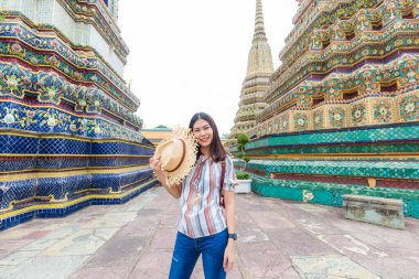 Sırt çantası ve şapka turuyla genç Asyalı gezgin kadınlar Buda tapınağında yürüyorlar, güzel Asyalı kadınlar.
