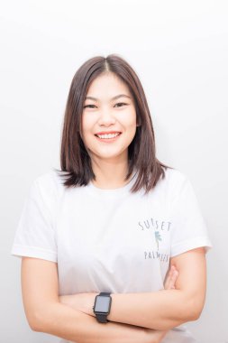 Beyaz arka planda rahatlayan ve gülümseyen çekici Asyalı genç kadınların portresi.