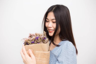 Güzel kadınlar beyaz arka planda bir buket kuru yabani çiçek tutuyorlar.