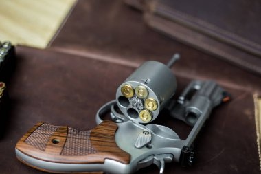 Ceketli 44 'lük magnum tabanca. Deri arka planda 240 tahıl mermisi.