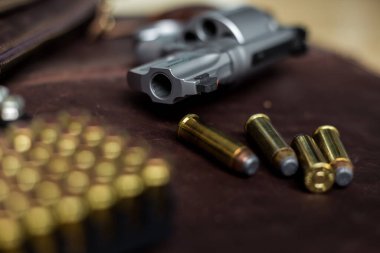 Ceketli 44 'lük magnum tabanca. Deri arka planda 240 tahıl mermisi.