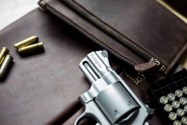Ceketli 44 'lük magnum tabanca. Deri arka planda 240 tahıl mermisi.