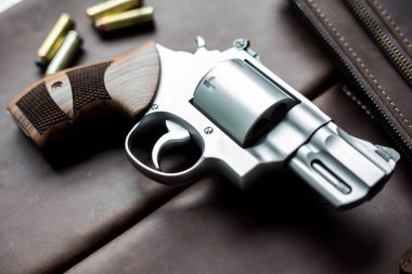 Ceketli 44 'lük magnum tabanca. Deri arka planda 240 tahıl mermisi.