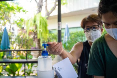 Asyalı kadınlar, alkol antiseptik jel ile ellerini yıkıyor. Covid-19 salgınını önlüyor. Kadın, el dezenfektanı ile ellerini yıkıyor.